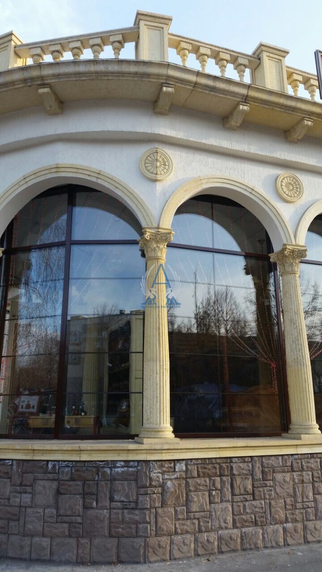 Фрагмент декора фасада здания. Капители и колонны коринфского ордера с энтазисом и канелюрами,подкровельным карнизом, кронштейнами